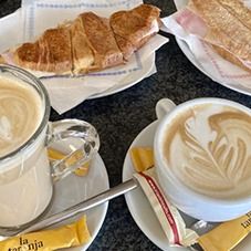 Griddled croissant with two coffees with milk